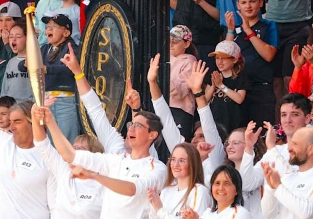 The Olympic flame makes a theme park visit on its way to Paris